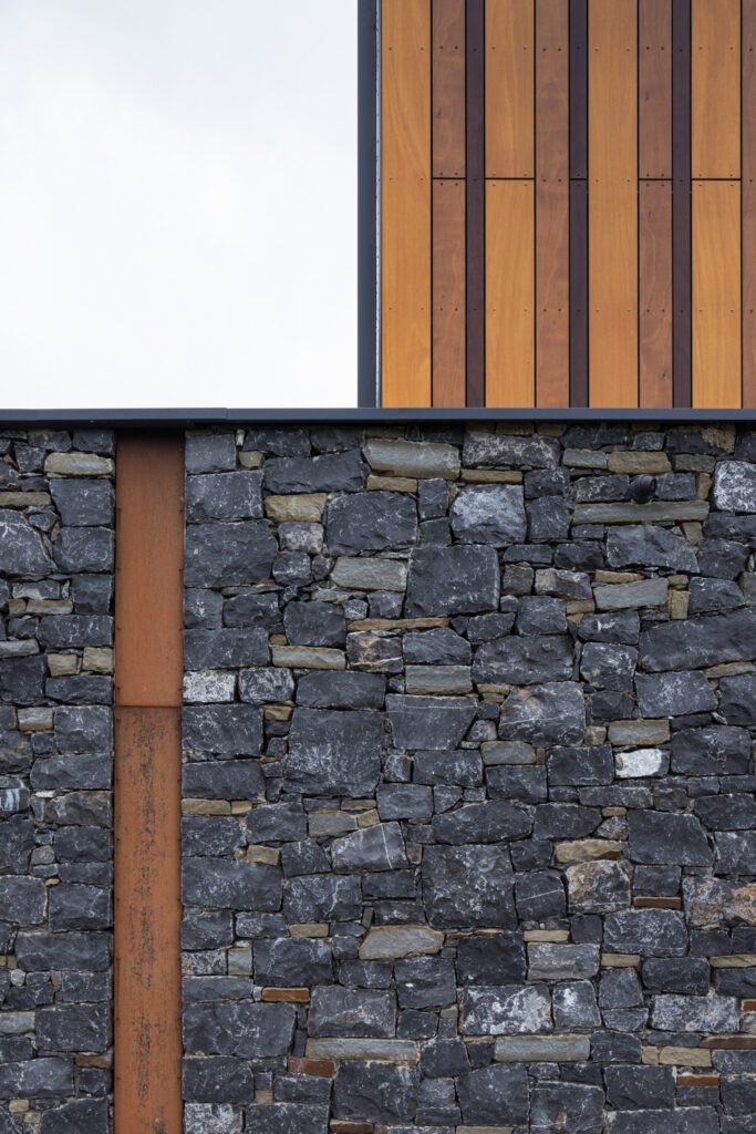 timber-cladding-sits-on-top-of-stone-wall-with-inset-steel-beam
