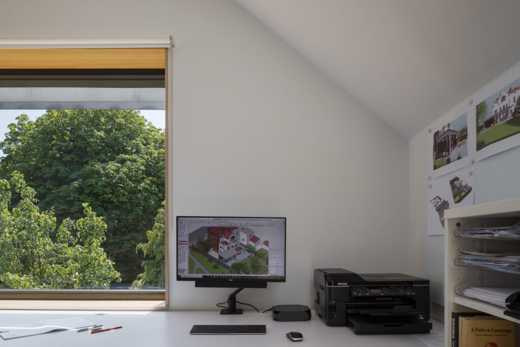tree-top-view-through-wooden-framed-window-from-architects-office-desk-with-computer