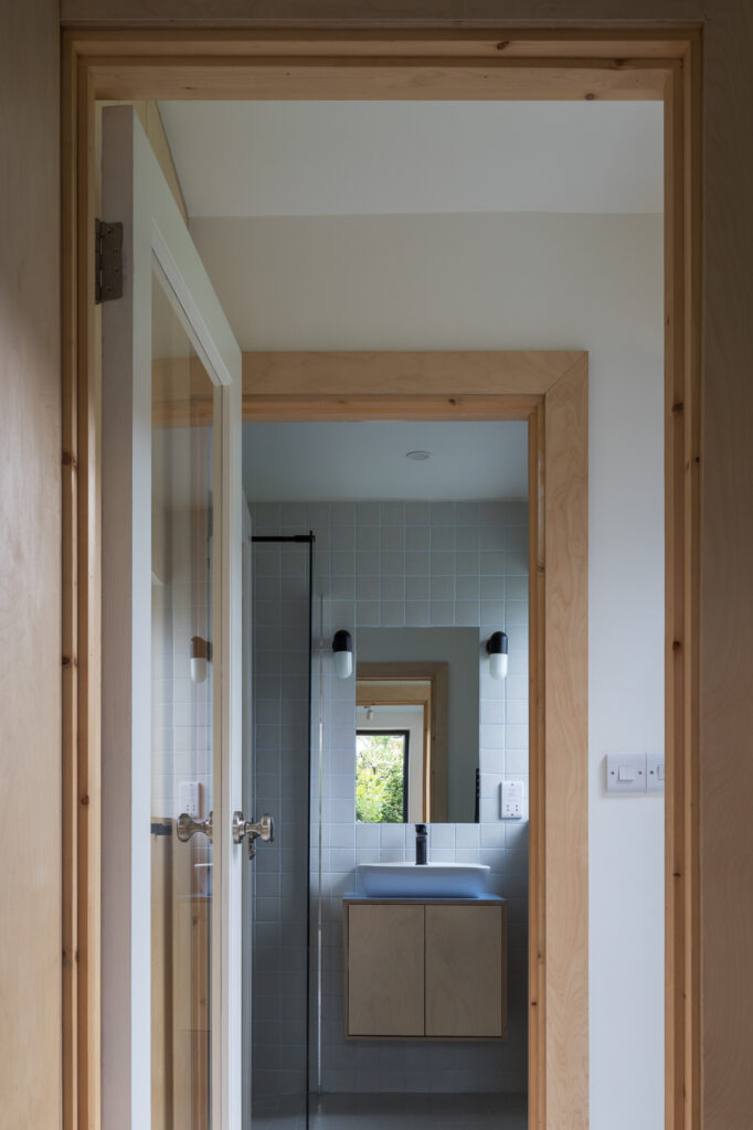 view-through-plywood-architraves-of-doors-of-plywood-vanity-and-bathroom-with-tiled-wall