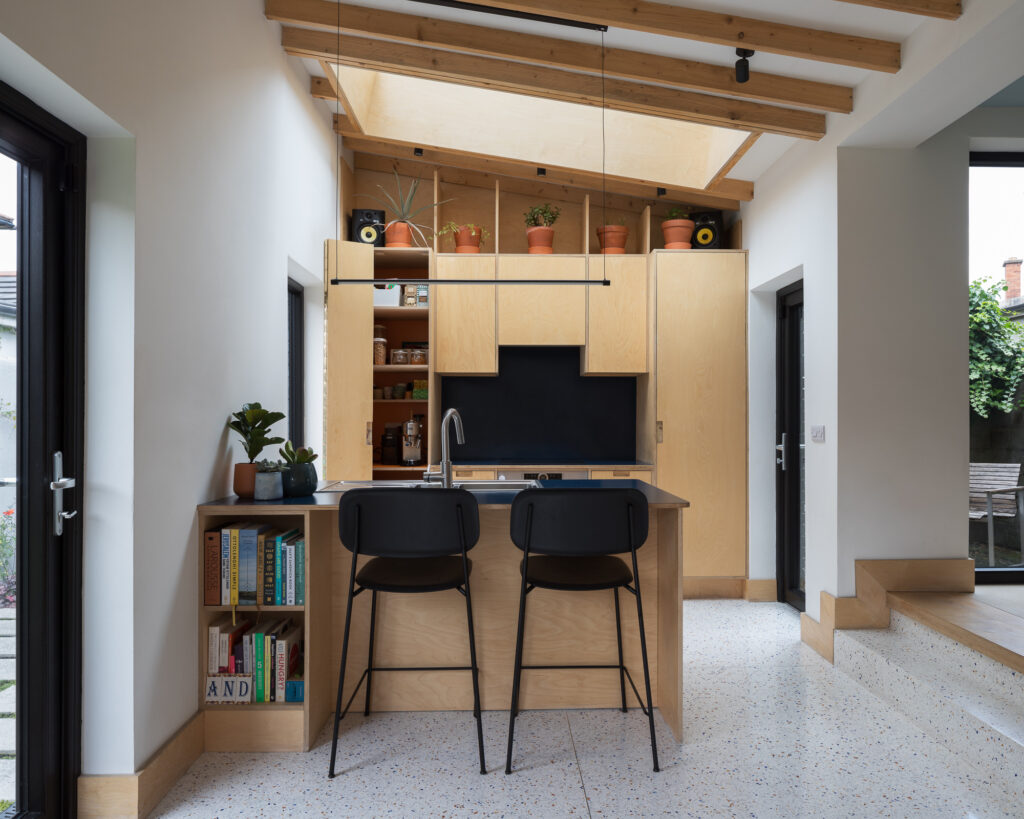 plywood-kitchen-with-speckled-terazzo-floor-and-monopitch-roof-with-roof-light