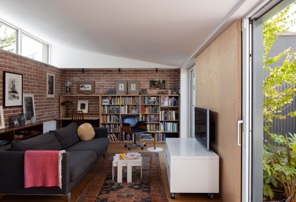 furnished-living-room-with-angled-roof-brick-walls-and-high-level-window