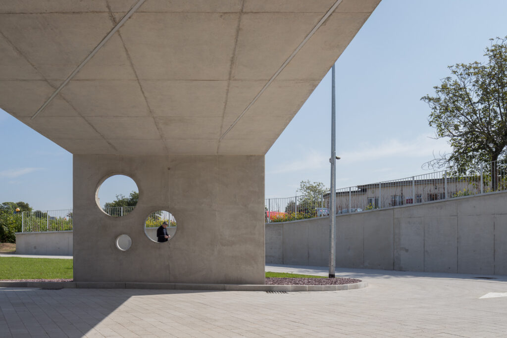 man-seen-through-holes-of-end-wall-of-concrete-canopy
