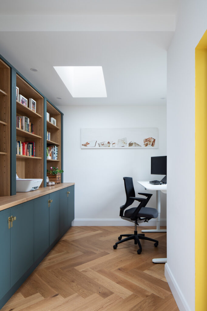 white-walled-office-with-wooden-herringbone-floor-and-wooden-shelving-and-desk-with-chair