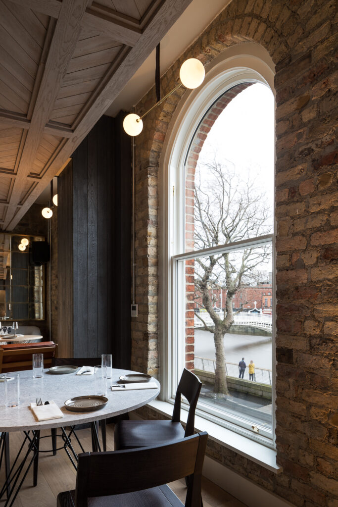 round-set-table-at-restaurant-with-brick-walls-and-view-of-the-ha'penny-bridge