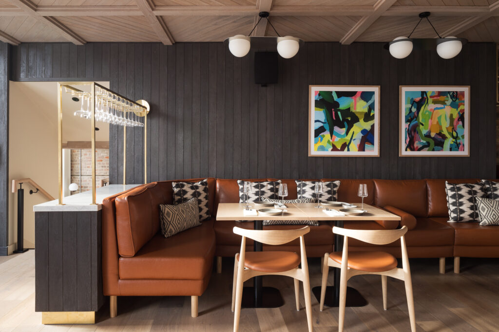 restaurant-with-dark-wood-lined-walls-and-long-leather-couch-running-along-wall