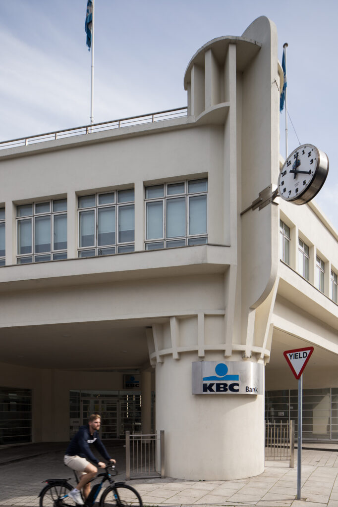 corner-column-of-art-deco-style-archers-garage-with-projecting-clock-as-a-cyclist-cycle-by