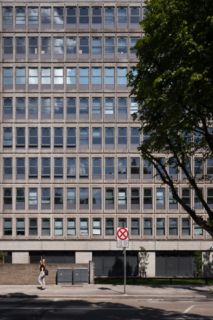 lansdowne-house-pre-cast-concrete-building-framed-by-tree-as-woman-walks-by