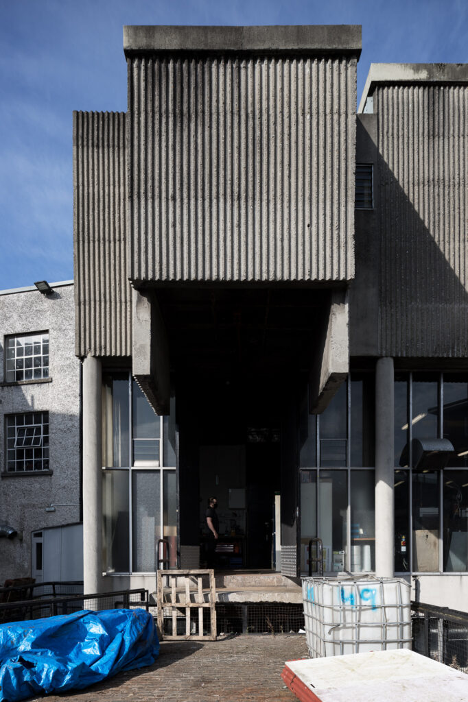 linenhall-school-of-trades-corrugated-concrete-building-with-man-standing-under-projecting-entrance
