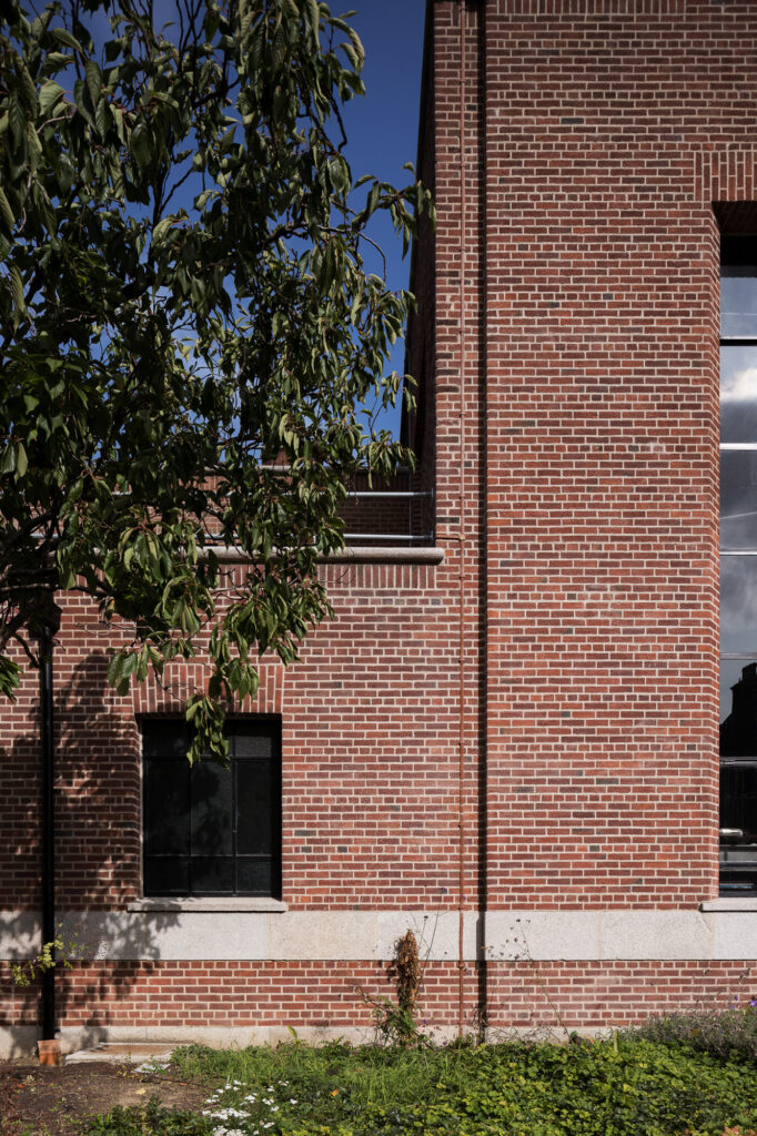 red-brick-wall-with-small-window-and-edge-of-taller-window-with-tree-in-front