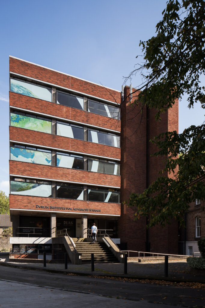 five-storey-red-brick-modernist-building-of-school-of-theoretical-physics-with-man-walking-up-steps