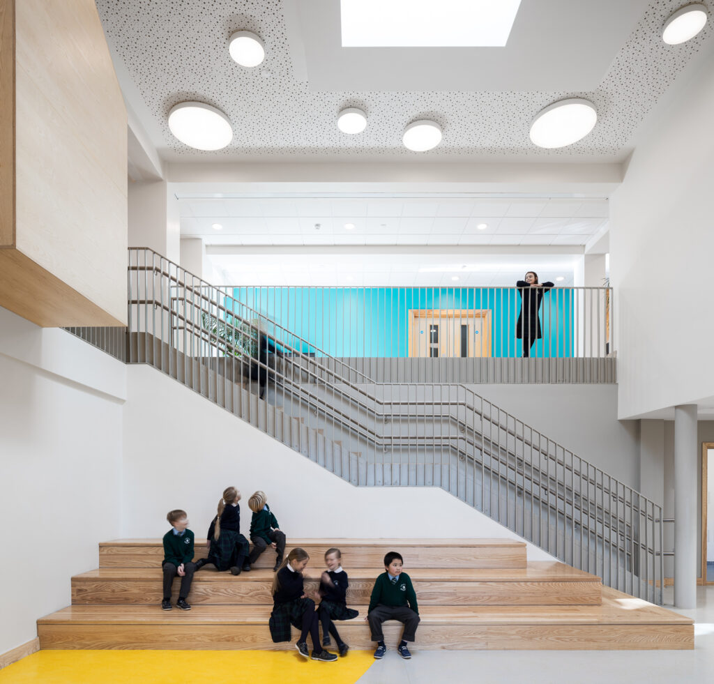 young-students-in-a-double-height-atrium-with-stepped-seating-stairway-and-balcony