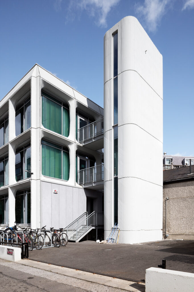 white-pre-cast-concrete-elements-of-texaco-house-with-green-tinted-glass-beside-four-storey-tower-with-vertical-slit-window