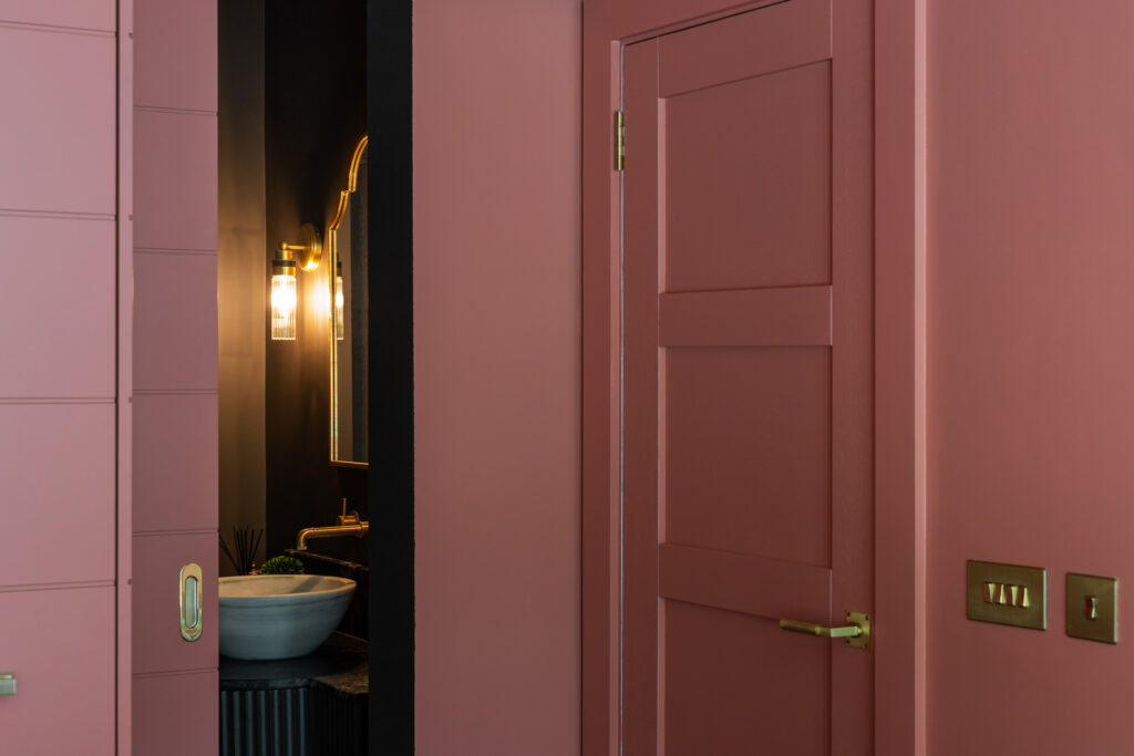 pink-room-with-sliding-door-leading-to-bathroom-vanity