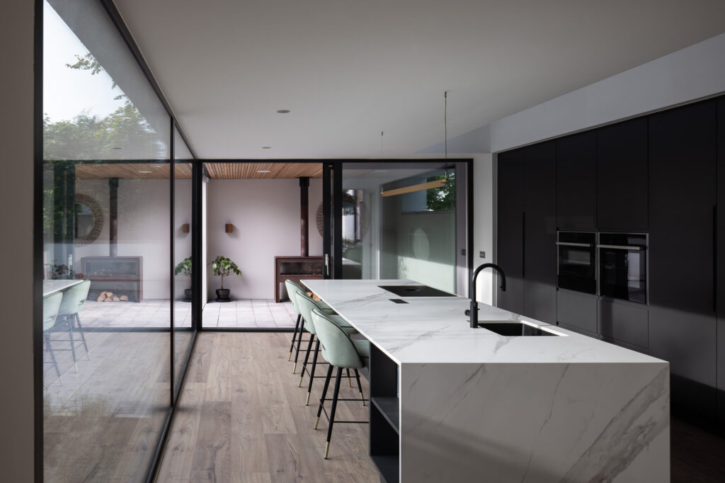 interior-black-kitchen-with-white-marble-island-and-green-stools
