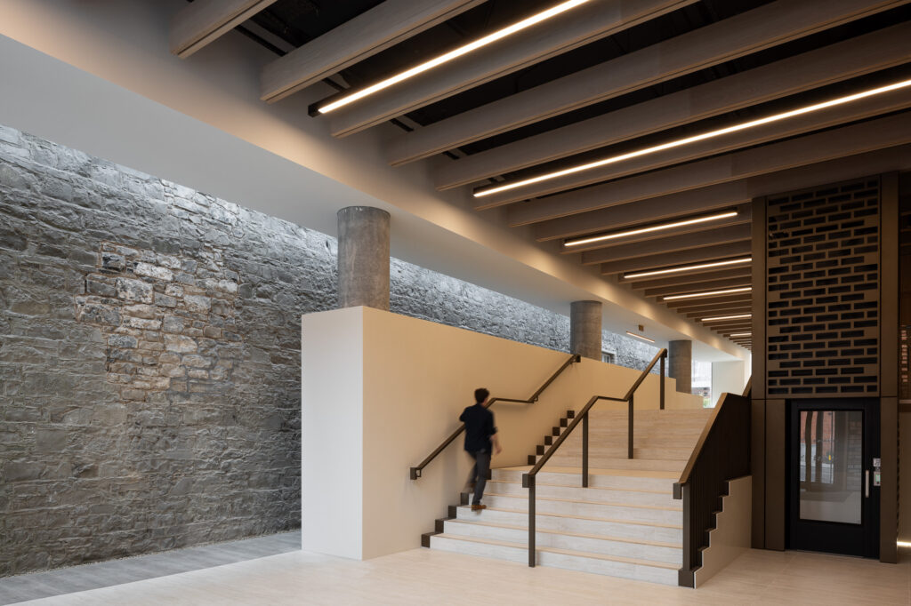 man-in-navy-shirt-walking-up-white-stone-stairs-of-entrance-hall