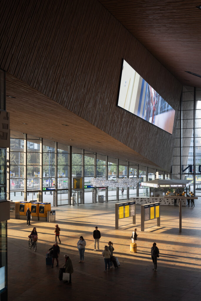 rotterdam-centrale-interieur-hal-bij-zonsopgang-met-zon-en-schaduw-cast-op-de-vloer-met-passagiers