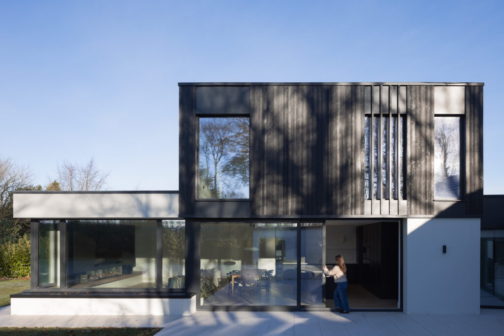 two-storey-extension-clad-in-charred-larch-with-women-opening-black-framed-slider