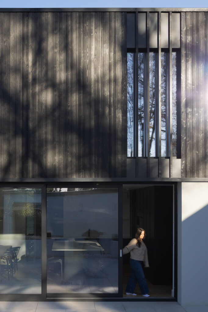 two-storey-extension-clad-in-charred-larch-with-women-opening-black-framed-slider