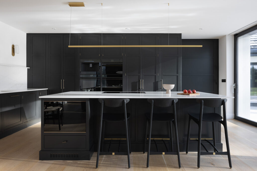 black-and-white-kitchen-with-island-with-wooden-chopping-board-with-red-apples-on-top-of-white-marble-counter-top