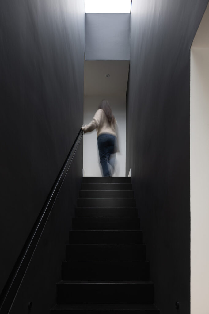 blurred-figure-of-woman-at-top-of-black-stairway