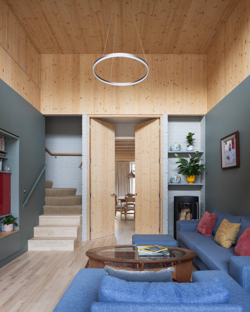 double-height-living-room-with-cross-laminated-timber-ceilings-and-high-door-to-dining-area