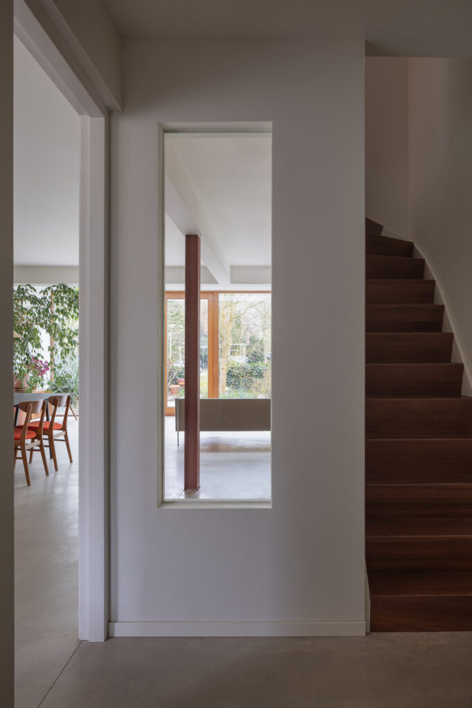 hallway-with-wooden-stairs-and-window-to-living-dining-area