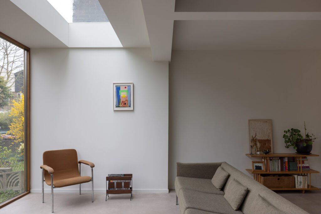 white-walled-living-area-with-exposed-concrete-floors-and-flat-roof-window