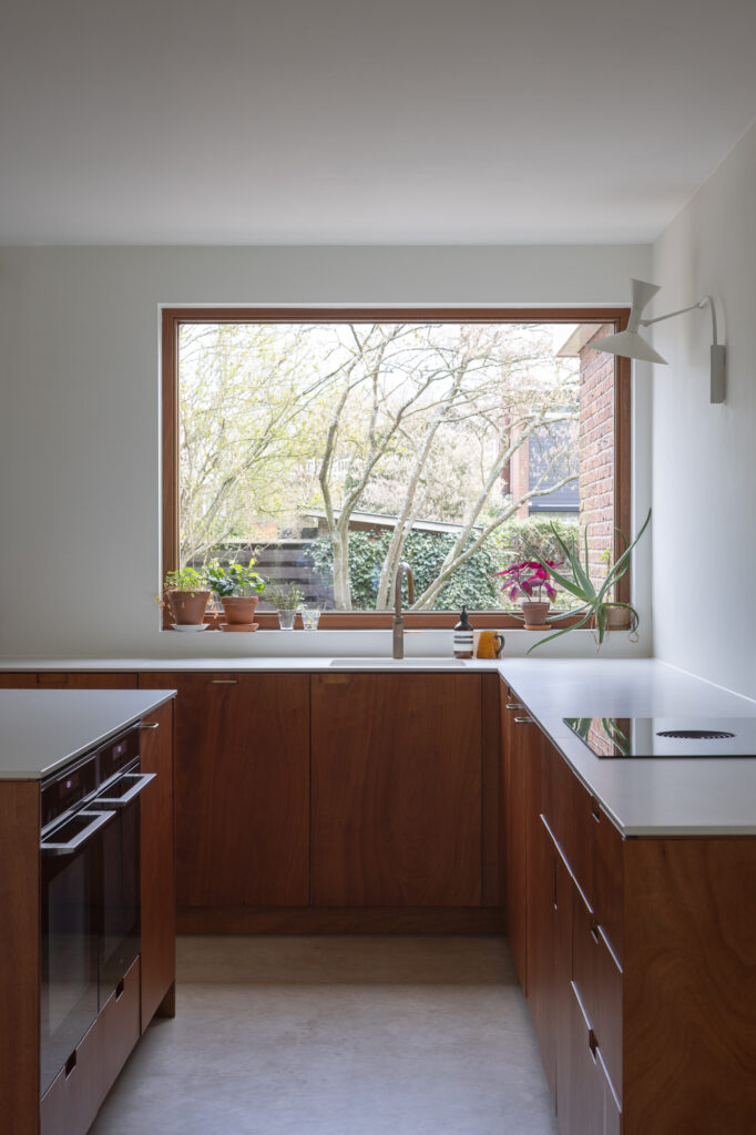 dark-wood-and white-counter-top-kitchen-with-wooden-window-frame