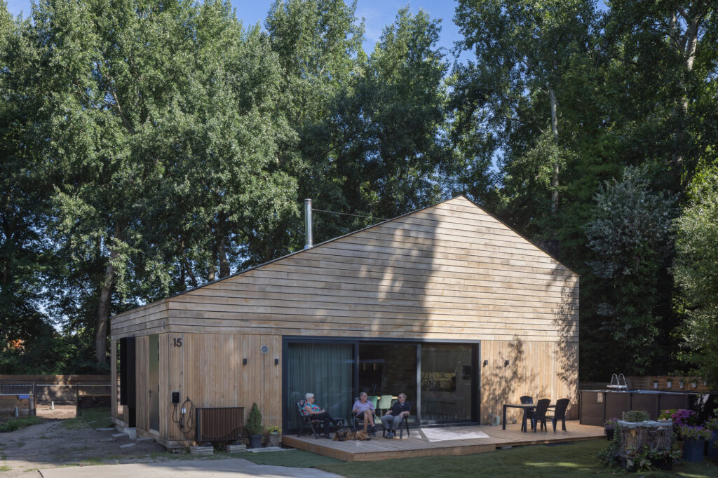 timber-clad-Barn-House-with-three-people-sitting-on-deck