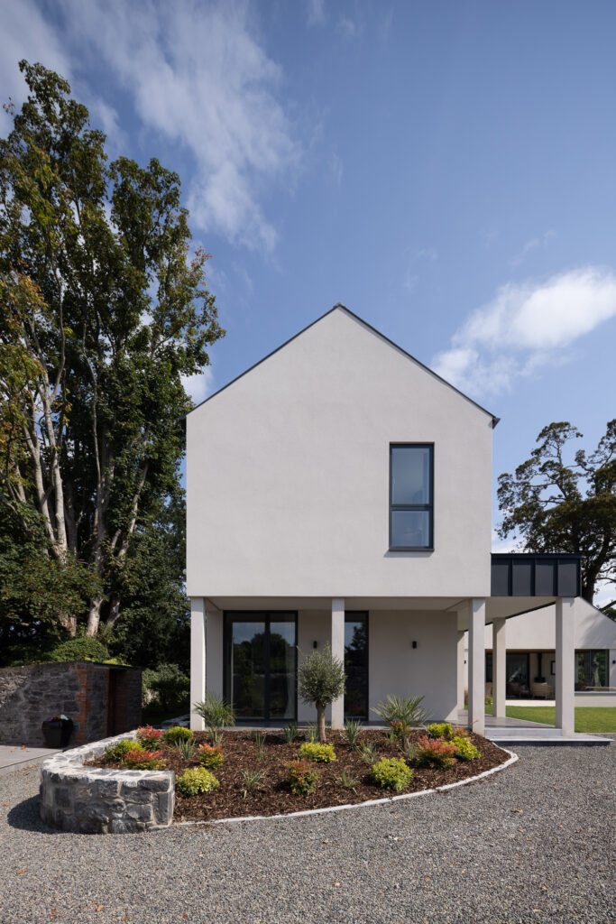 two-storey-pitched-gable-end-over-colonnade-with-curved-garden-bed-with-plants