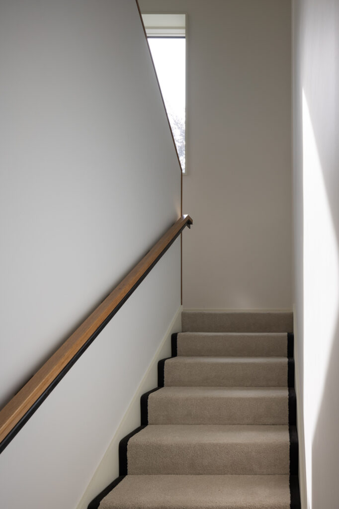 carpeted-stairway-with-wooden-handle