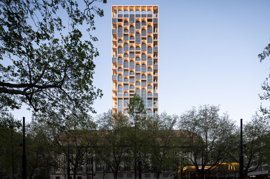 post-rotterdam-tower-peeking-above-old-post-office-building-and-trees-at-sunset